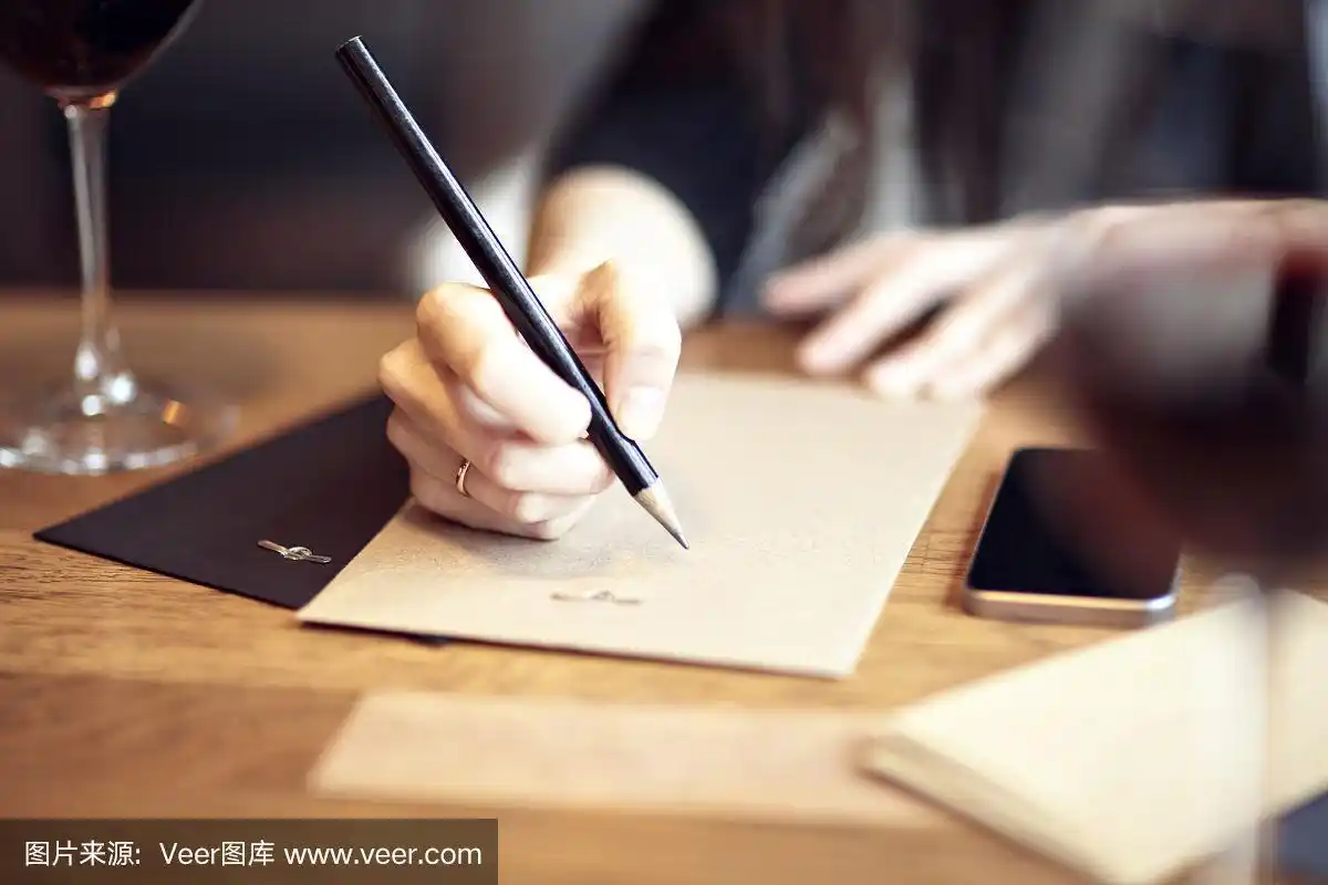 在餐馆里写字的手的特写.业务.静止的.酒
