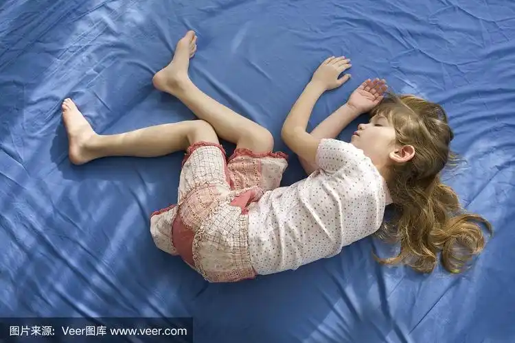 睡着的小女孩躺在床上.蓝色的棉片