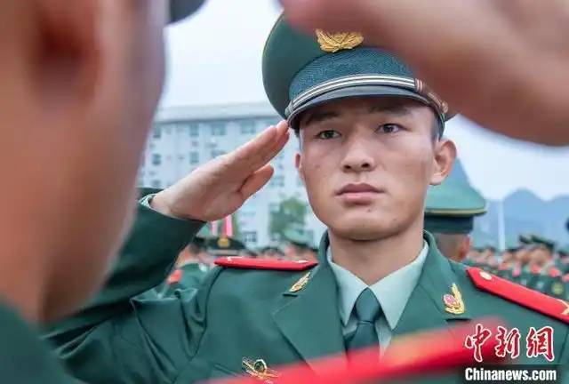 武警新兵相互佩戴肩章,领花等标识.