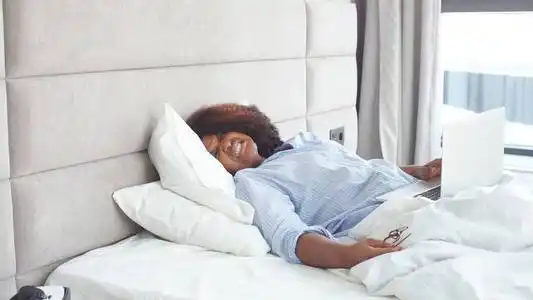 累得昏昏欲睡的男人在笔记本电脑上工作直到半夜才上床睡觉昏昏欲睡的