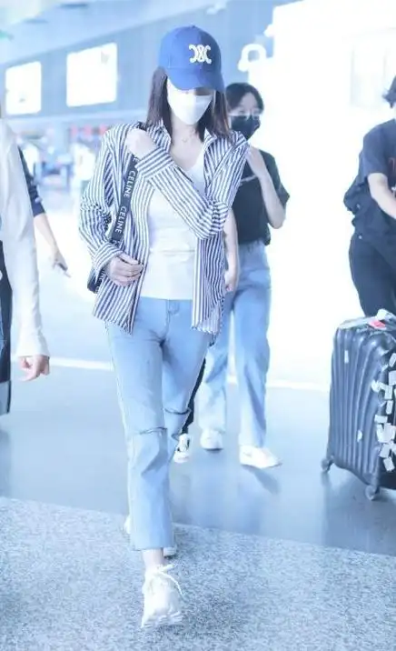 李小冉里面穿白色背心,下身搭配破洞牛仔裤,秀出了纤细的腰部线条和