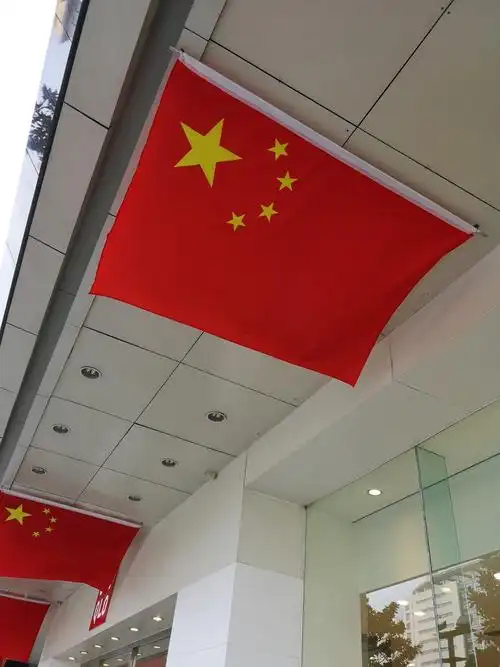 悬挂着一排红色五星红旗,见"旗杆"都横放,在微风中五星红旗随风飘动着