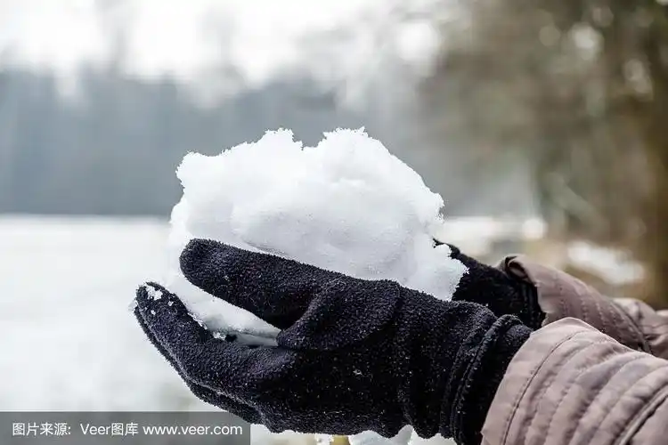 戴着手套的手捧着雪