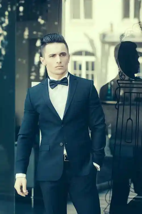 站在玻璃门前的穿西装打领带结的帅气男人