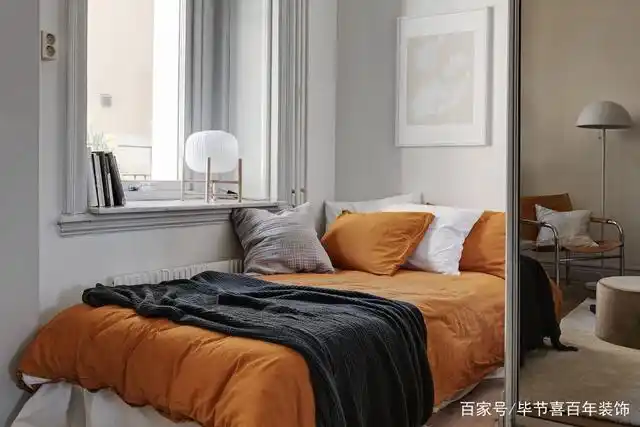 次卧靠近窗户,橘色的床上用品带来一些特别的视觉感受.
