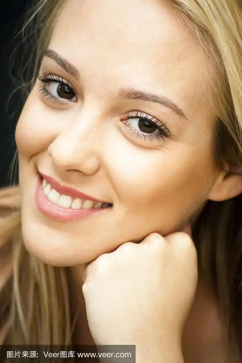 美丽的年轻女子用手托着脸