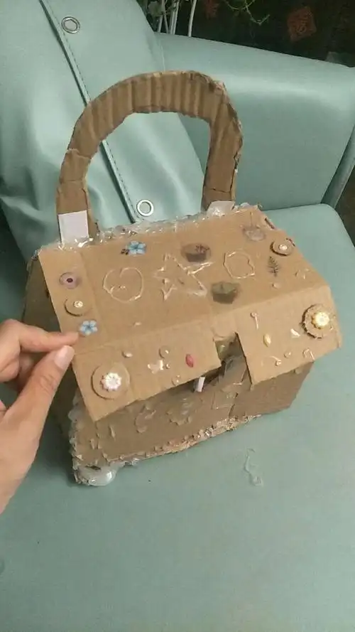 利用硬纸盒子只做了一个实用又美观的小包包,上面用速溶胶