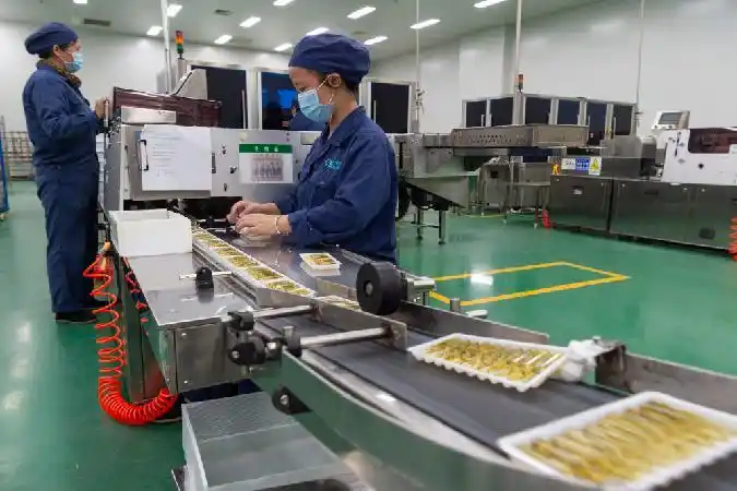 在湖北天药药业股份有限公司的生产车间中,工人在药品生产线上