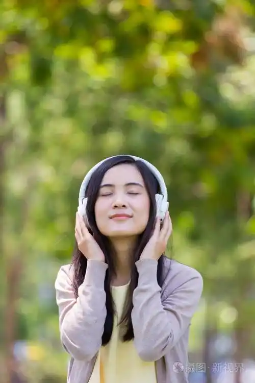 亚洲美女听音乐与白色耳机在na