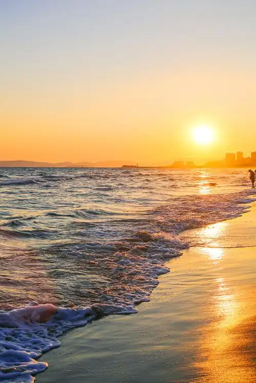 夕阳的光辉在海水和沙滩上撒下一条金灿灿
