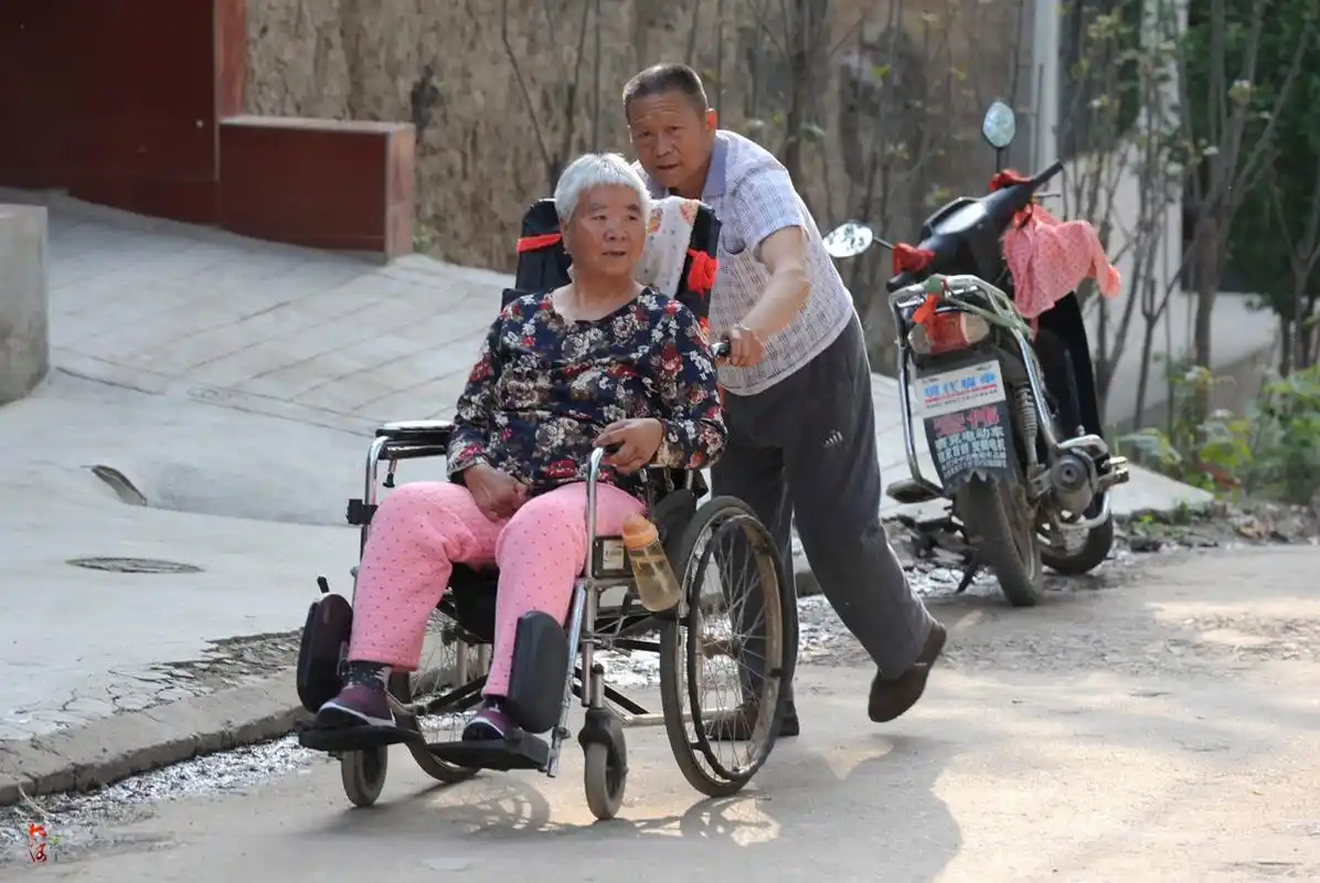 6旬大爷推半身不遂妻子马路边看车:让她高兴一天是一天