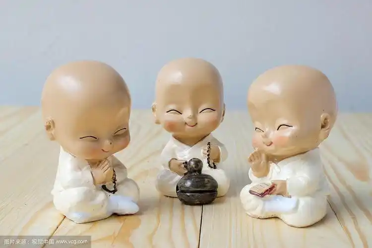 小和尚正在祈祷,松木背景上的新和尚雕像