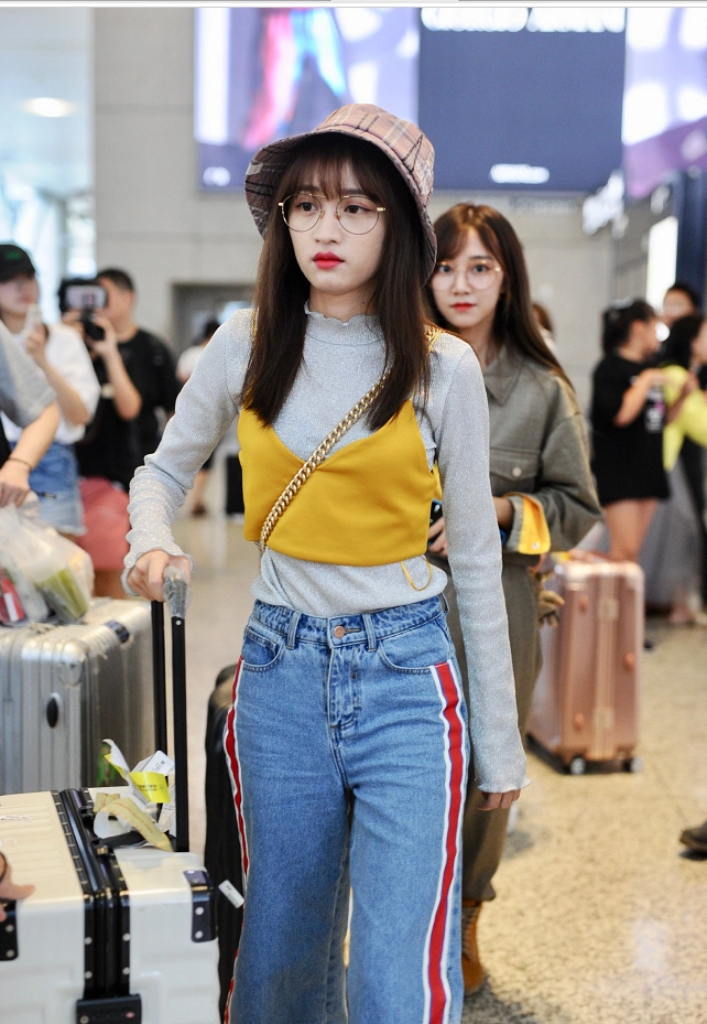 总选后黄婷婷身着黄色吊带外套现身机场 戴圆框眼镜变文艺少女