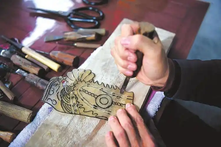 一位游客在观赏皮影人传承人陈雨伦在给游客表演皮影戏