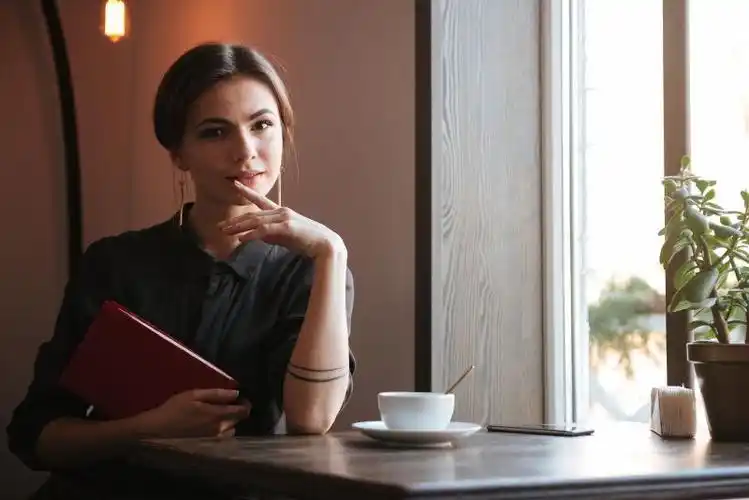 窗户旁喝咖啡的年轻美女