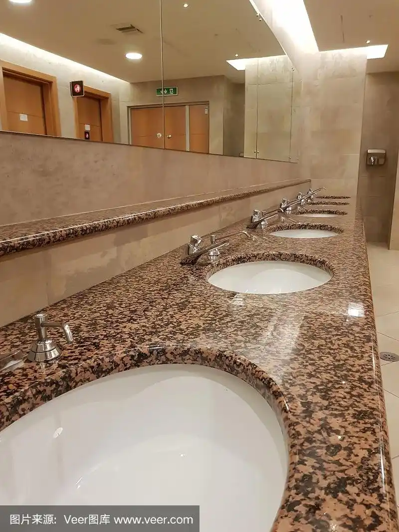 公共卫生间,在浴室的陶瓷洗脸盆中排镀铬水龙头,卫生间水槽内部.