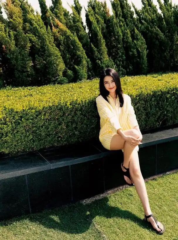 高圆圆身穿黄白条纹衬衫短裤,漫步花园,充满夏日气息