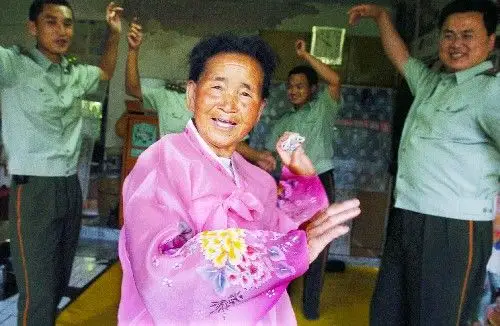 8月15日,朝鲜族老人金顺子与芦果派出所的官兵跳起朝鲜族舞蹈.