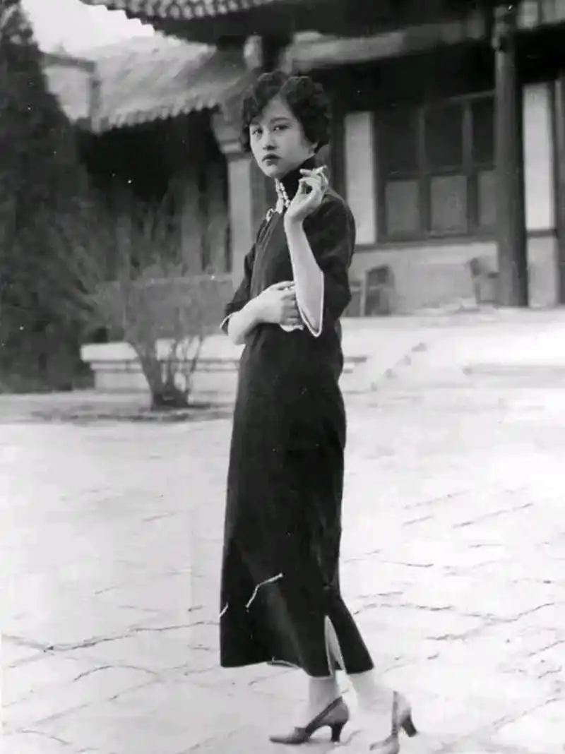 一幅民国时期的老照片中,身着旗袍和高跟鞋的女子引人注目.