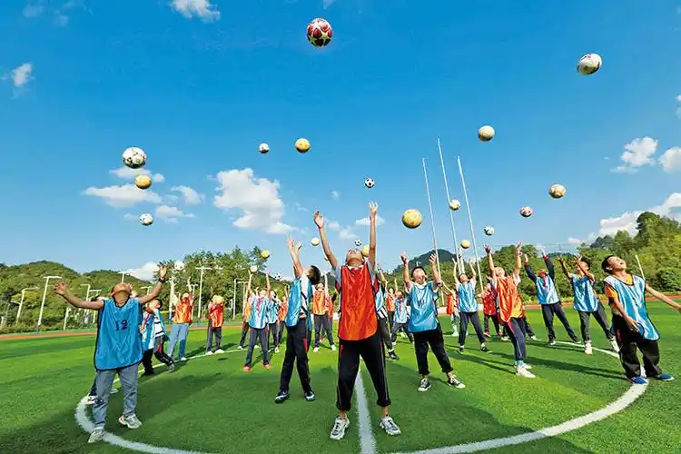 孩子们在老师的带领下,通过互动游戏的方式学习足球知识,在校园里尽享