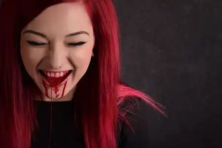 笑鬼微笑在她脸上的血的吸血鬼女人照片