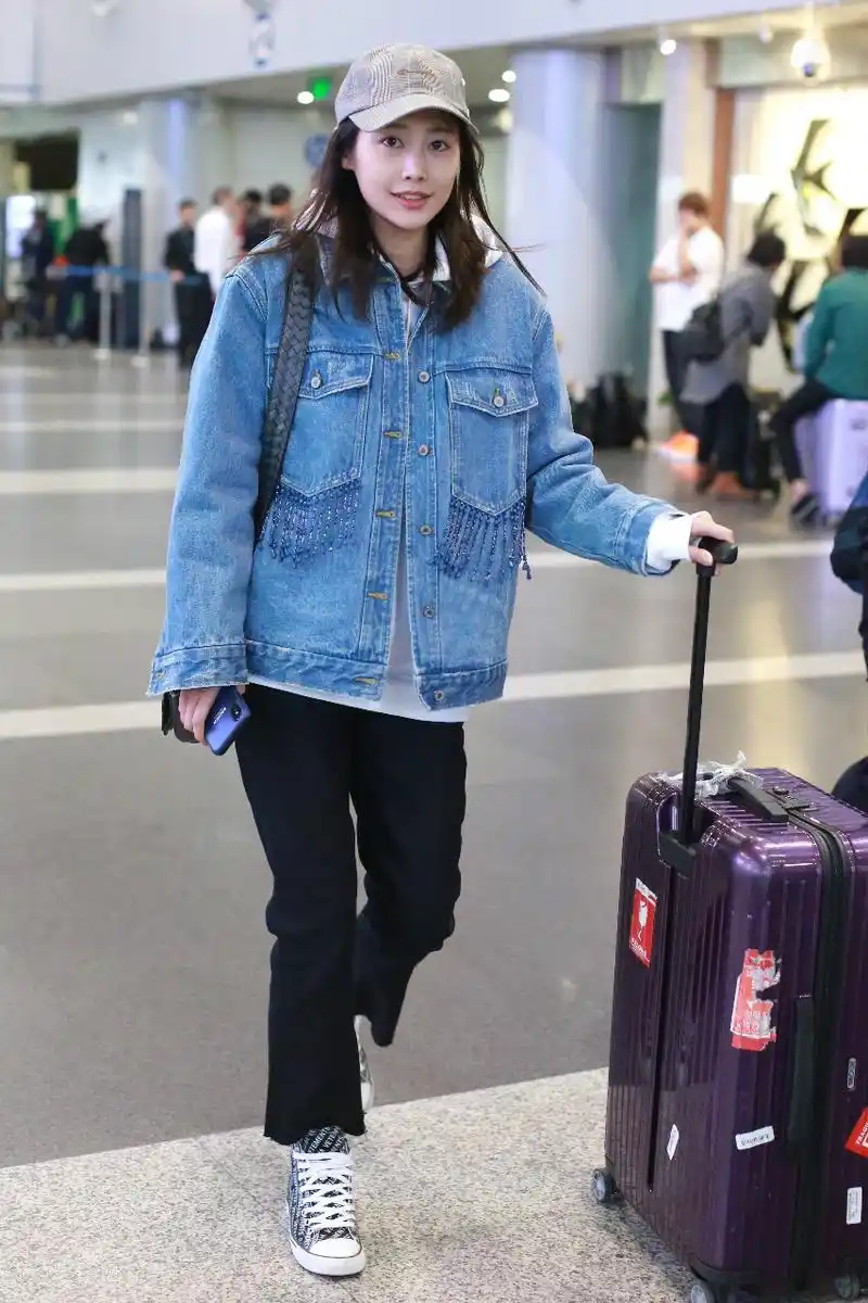 李纯穿蓝色牛仔衣搭配黑色喇叭裤现身机场,皮肤白皙笑容灿烂