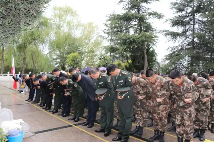 全体人员脱帽,庄严地向烈士行鞠躬礼.