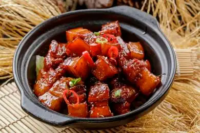 寿司帘上的黑色砂锅装的毛氏红烧肉