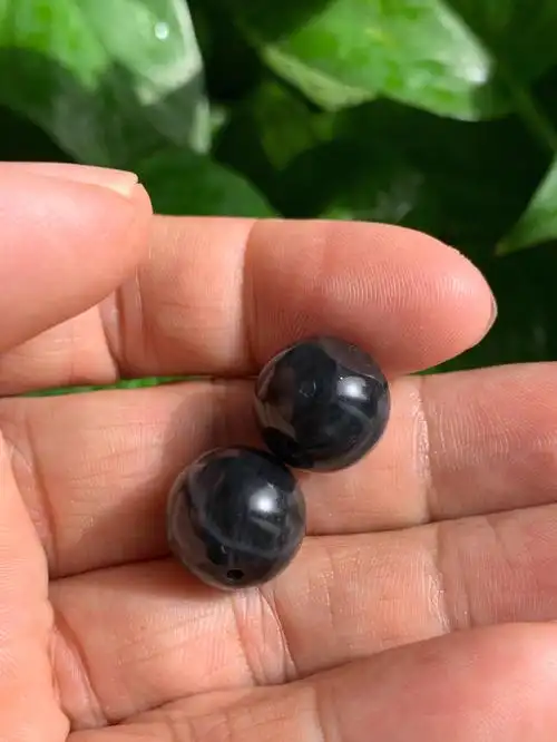 同料2粒墨玉籽料珠子均留有皮色其中一颗眼