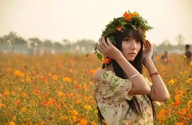 适合在花丛中拍照的姿势很多,低头闻花香或者把花捧在胸前,显示出模特