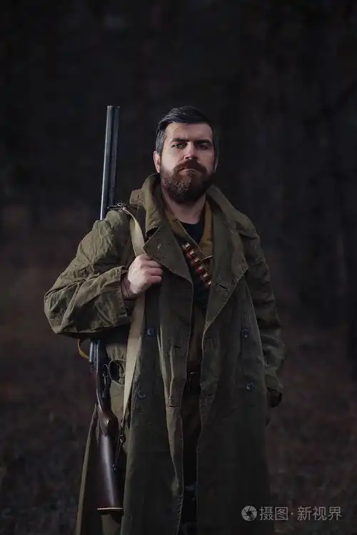 大胡子的猎人与专业设备走在丛林中