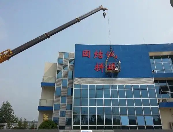 (图 :正在进行的二水厂综合楼外墙的标语上墙工作)