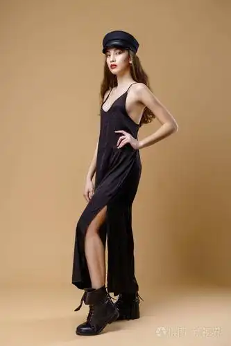 华丽年轻时尚模特在摄影棚背景上摆姿势的全长肖像