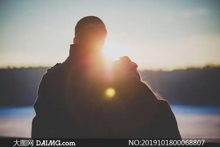 清晨相互依偎看日出的情侣摄影图片