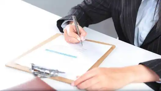 商业妇女坐在桌子上,写一篇论文照片