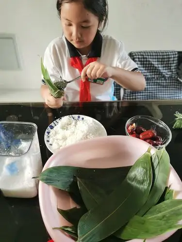桃力民小学一(2)班高晨辰端午节手工之包粽子,编五彩绳.