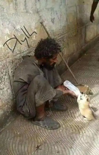 一位乞丐正在给小家伙喂奶,看到这一幕感到心里一阵心酸