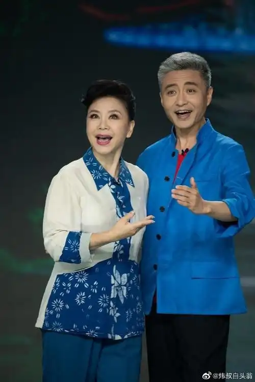 45岁周炜和娇妻散步穿军大衣头发花白像60岁和妻子像父女