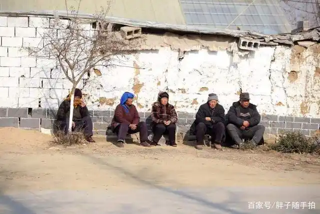 坐在墙角晒太阳的农村老人