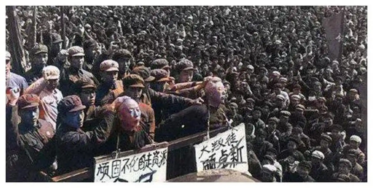 在这张照片中,两个罪犯胸前挂着牌子,其中一个标着"顽固不化的走资派