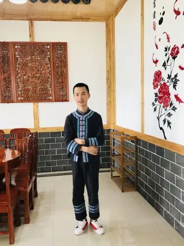 身穿布依族民族服装的帅气小哥,话语不多,服务周到.