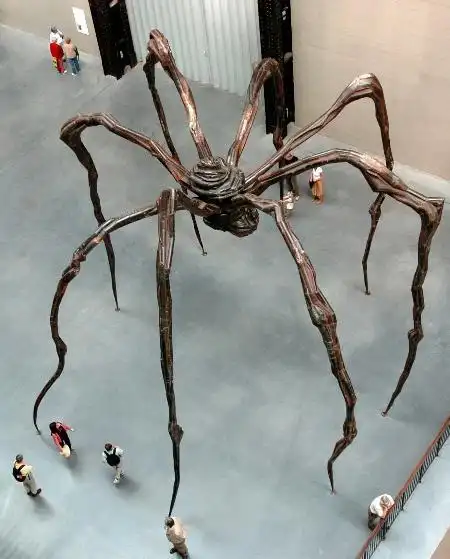 几名参观者在英国伦敦泰特现代艺术馆观看一个巨型蜘蛛雕塑