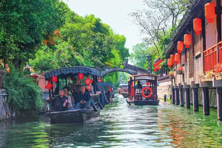 湖州市南浔古镇阳光明媚,游客乘坐摇橹船欣赏风景(2024年4月24日摄)