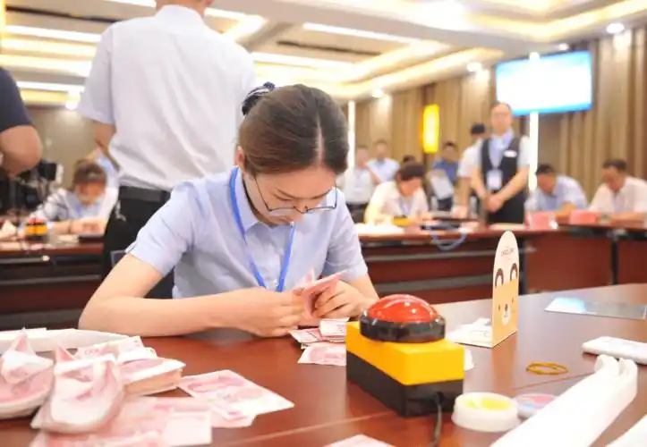 高手对决 精彩纷呈点钞比赛分为三组进行,每组8位选手分别参加点钞识