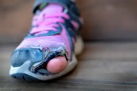 或模具制作鞋子脏地板上破了的旧鞋子与孔无家可归脚趾露在外面的旧