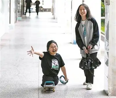 蒋张子怡(左)和同学在学校的走廊聊天.