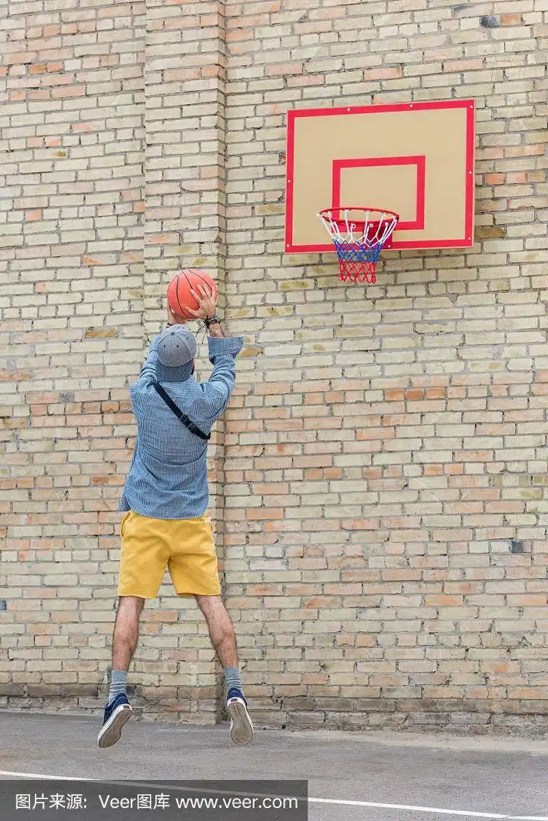 年轻男子独自打篮球的背影