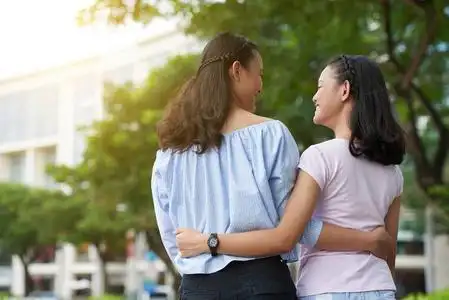 拥抱的可爱亚洲姐妹拥抱到户外散步的女孩照片