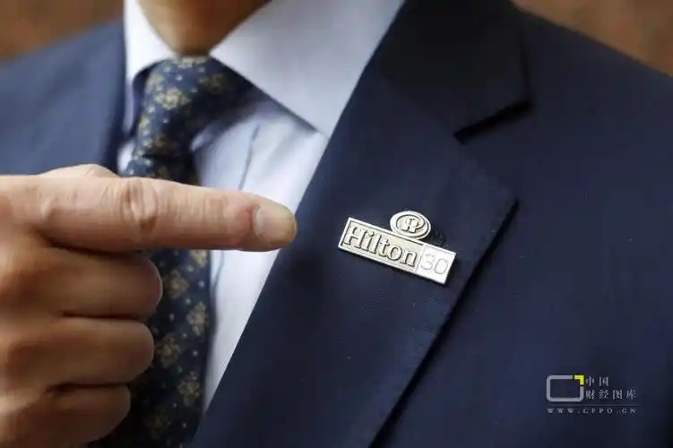 一位上海希尔顿酒店的保安经理,西装领子上佩戴着象征工作30年的胸牌.