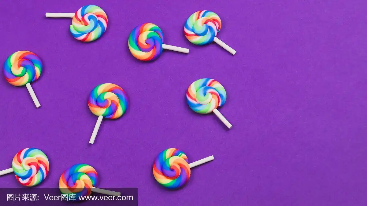 紫色背景上的棒棒糖.节日的概念.本空间